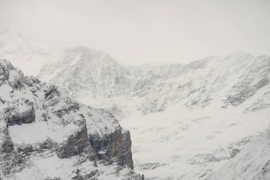 Kışın İsviçre dağlarının manzarası. Bulutlardaki Eiger, Monoch ve Jungfrau. İsviçre 'nin Jungfrauregion bölgesindeki İsviçre Alpleri