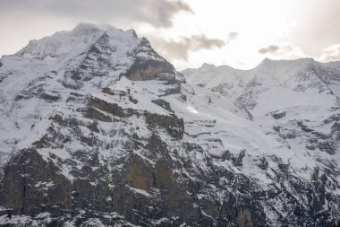 Kışın İsviçre dağlarının manzarası. Bulutlardaki Eiger, Monoch ve Jungfrau. İsviçre 'nin Jungfrauregion bölgesindeki İsviçre Alpleri