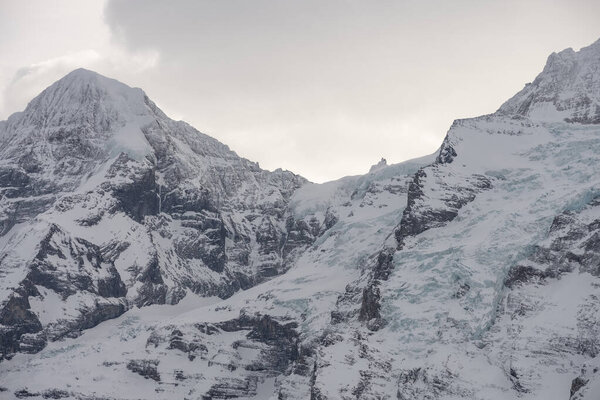 View of the Swiss mountains in winter. Eiger in clouds, Monoch and Jungfrau. Swiss alps in Jungfrauregion in Switzerland
