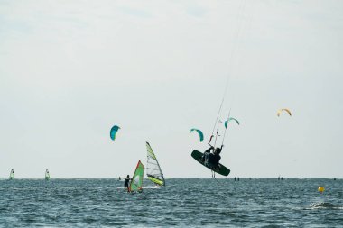 İnsanlar denizde uçurtma sörfü ya da uçurtma sörfü ile yüzerler. Yaz sporu uçurtma uçurmayı öğreniyor. Jastarnia, Polonya ve Avrupa 'daki Puck Bay' de uçurtma sörfü