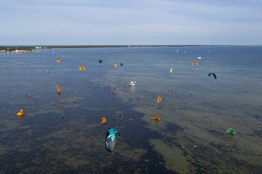 İnsanlar denizde uçurtma sörfü ya da uçurtma sörfü ile yüzerler. Yaz sporu uçurtma uçurmayı öğreniyor. Jastarnia, Polonya 'daki Puck Bay' de uçurtma sörfü, Avrupa 'nın insansız hava aracı görüntüsü