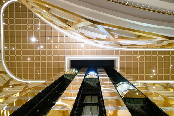 Main staircase in lobby of luxury hotel, golden  expensive luxury resort. Golden design of the hotel with beautiful lamps and elevators. Vacation resort in Side, Antalya, Turkey