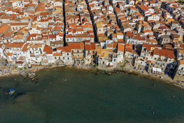 Sicilya adasının kuzey kıyısında, İtalya 'nın güneyinde, Akdeniz kıyısında, katedral plajı ve turkuaz Tyrhenian Denizi olan Cefalu tarihi ortaçağ kasabasının insansız hava aracı görüntüsü..