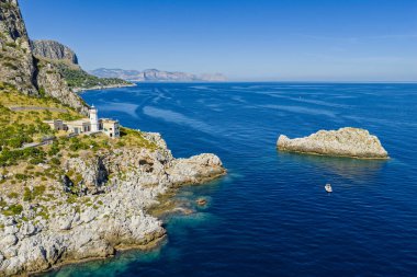 Capo Zafferano İtalyan kıyı filosu ve deniz feneri insansız hava aracı Bagheria, Sicilya 'daki Tyrhenian Denizi kıyısında engebeli kayalıkları Akdeniz flora kristal berrak suyu ile yemyeşil.