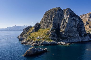 Capo Zafferano İtalyan kıyı filosu ve deniz feneri insansız hava aracı Bagheria, Sicilya 'daki Tyrhenian Denizi kıyısında engebeli kayalıkları Akdeniz flora kristal berrak suyu ile yemyeşil.