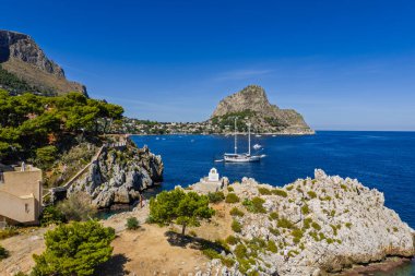 Porticello, Santa Flavia, Sicilya, İtalya 'daki Sant Elia körfezi plajı, Sicilya turkuvaz suları, kayalık uçurumlar, renkli evler ve Bagheria' daki Akdeniz kıyı şeridi manzarası..