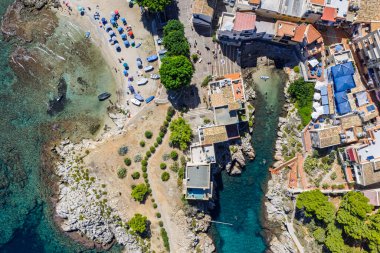 Porticello, Santa Flavia, Sicilya, İtalya 'daki Sant Elia körfezi plajı, Sicilya turkuvaz suları, kayalık uçurumlar, renkli evler ve Bagheria' daki Akdeniz kıyı şeridi manzarası..