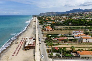 Sicilya, İtalya 'nın kuzeyinde büyüleyici bir Sicilya sahil kasabası olan Campofelice di Roccella' nın insansız hava aracı görüntüsü geleneksel tatil evleri, kıyı şeridi ve panoramik Tiren Denizi manzaralarını gösteriyor..