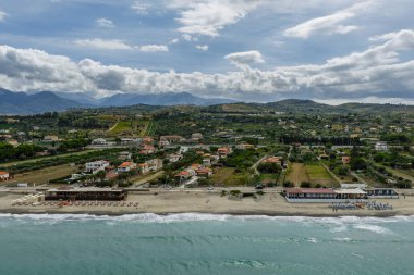Sicilya, İtalya 'nın kuzeyinde büyüleyici bir Sicilya sahil kasabası olan Campofelice di Roccella' nın insansız hava aracı görüntüsü geleneksel tatil evleri, kıyı şeridi ve panoramik Tiren Denizi manzaralarını gösteriyor..