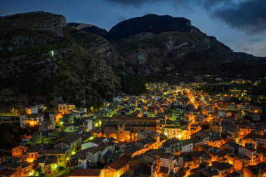 Collesano 'nun hava aracı gece görüşü. Sicilya' nın Sicilya bölgesindeki Madonie Dağları 'nda Basilica San Pietro kilisesi ve aydınlık taş sokaklar ile birlikte alacakaranlıkta tarihi bir Sicilya dağ kasabası..