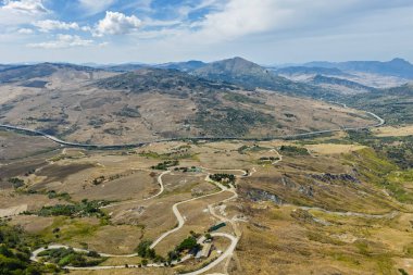 Polizzi Generosa 'nın hava aracı görüntüsü, Sicilya' nın Sicilya, İtalya 'daki Madonie Dağları' nın geleneksel taş binaları ve panoramik manzarasını gösteren kayalık uçurumlara tünemiş Sicilya dağ kasabası..