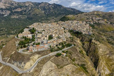 Polizzi Generosa 'nın hava aracı görüntüsü, Sicilya' nın Sicilya, İtalya 'daki Madonie Dağları' nın geleneksel taş binaları ve panoramik manzarasını gösteren kayalık uçurumlara tünemiş Sicilya dağ kasabası..