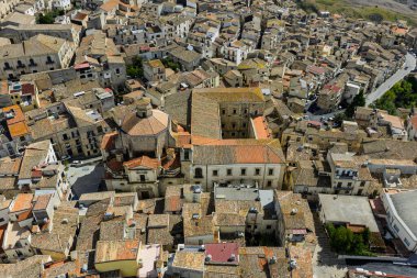 Polizzi Generosa 'nın hava aracı görüntüsü, Sicilya' nın Sicilya, İtalya 'daki Madonie Dağları' nın geleneksel taş binaları ve panoramik manzarasını gösteren kayalık uçurumlara tünemiş Sicilya dağ kasabası..