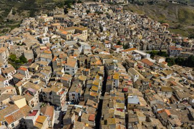 Polizzi Generosa 'nın hava aracı görüntüsü, Sicilya' nın Sicilya, İtalya 'daki Madonie Dağları' nın geleneksel taş binaları ve panoramik manzarasını gösteren kayalık uçurumlara tünemiş Sicilya dağ kasabası..