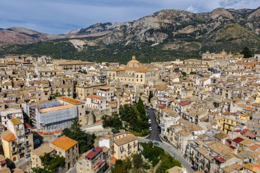 Polizzi Generosa 'nın hava aracı görüntüsü, Sicilya' nın Sicilya, İtalya 'daki Madonie Dağları' nın geleneksel taş binaları ve panoramik manzarasını gösteren kayalık uçurumlara tünemiş Sicilya dağ kasabası..