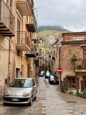 Collesano, a historic Sicilian mountain town in the Madonie Mountains, featuring narrow stone streets, traditional houses, and the Church of San Pietro, Sicily, Italy. Italian town in hills.