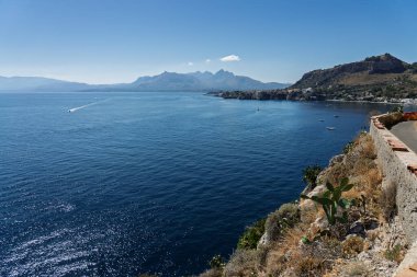 Capo Zafferano Italian coastal promontory and lighthouse by the Tyrrhenian Sea in Bagheria, Sicily Italy with rugged cliffs lush Mediterranean flora crystal clear water.