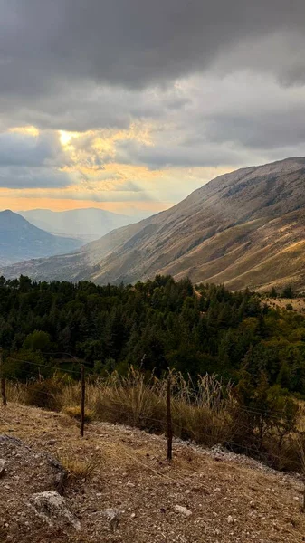 Mountainous central Sicilian landscape near Campofelice di Roccella, Italy, featuring rolling hills, distant Tyrrhenian Sea views, and the volcanic Islands on the horizon under.