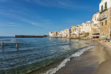 Cefalu, a historic Sicilian coastal town in northern Sicily, Italy, charming narrow streets, the Cathedral Basilica of the Transfiguration of the Lord, golden beach, and view of the Tyrrhenian Sea.