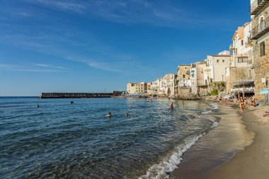 Cefalu, a historic Sicilian coastal town in northern Sicily, Italy, charming narrow streets, the Cathedral Basilica of the Transfiguration of the Lord, golden beach, and view of the Tyrrhenian Sea.