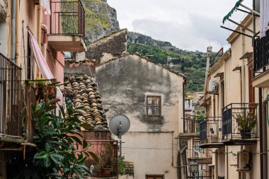Collesano, a historic Sicilian mountain town in the Madonie Mountains, featuring narrow stone streets, traditional houses, and the Church of San Pietro, Sicily, Italy. Italian town in hills.