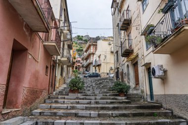 Collesano, a historic Sicilian mountain town in the Madonie Mountains, featuring narrow stone streets, traditional houses, and the Church of San Pietro, Sicily, Italy. Italian town in hills.