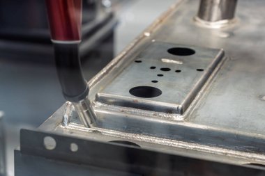 Robot çeliği kaynak yapar. Kaynak kafa. Kaynak robotu. CNC kaynaklama. Kaynak işleminin robotlaştırılması ve otomasyonu. Robot kaynak çeliği. Endüstriyel kaynak robotu ve metal parçalarıyla çalışıyor.