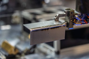 Robot çeliği kaynak yapar. Kaynak kafa. Kaynak robotu. CNC kaynaklama. Kaynak işleminin robotlaştırılması ve otomasyonu. Robot kaynak çeliği. Endüstriyel kaynak robotu ve metal parçalarıyla çalışıyor.