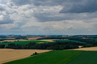 Polonya 'da Opole ve Nysa yakınlarındaki kırsal köylerin ve tarım alanlarının insansız hava aracı görüntüsü geometrik tarım arazileri, dağınık evler, dolambaçlı kır yolları ve gün ışığında yeşil çayırlar gösteriyor..