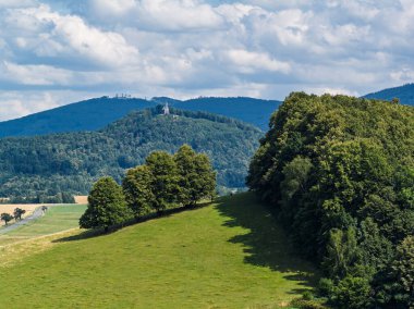 Çek Cumhuriyeti 'nin Bozi Hora tepesindeki tarihi kilisesinin, geleneksel çatılarının, yeşilliğin çevresindeki Zulova kasabasının insansız hava aracı görüntüsü ve gün ışığında yakalanan huzurlu kasaba düzeni..