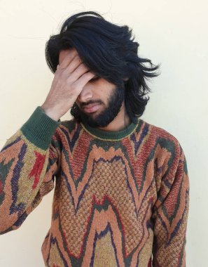 Yorgun bir gencin fotoğrafı, sakallı, uzun saçlı yakışıklı bir genç adam, alnında el resmi olan üzgün bir adam. 