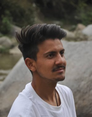 Nehrin kenarında duran beyaz tişörtlü yakışıklı genç bir adam. 