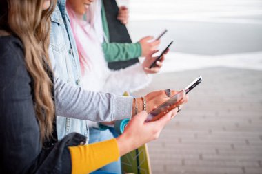 Akıllı telefonu kullanan arkadaşlarının yakın çekim elleri - cep telefonlarında yazan ve sohbet eden adamlar