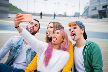 Group of teneegers making  faces and joking together while a video call with their friends - Group of friends on vacation taking a selfie to remember this special moment