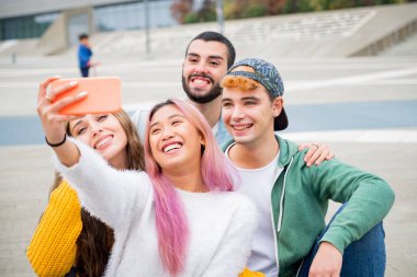 Group of young friends taking a selfie in the city - Happy millennials sharing content on social media - People, technology and lifestyle