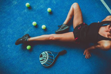 Genç kız oyuncu ve padel ya da tenis objelerini kapat