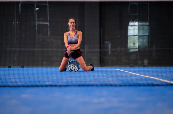 Padel tenis kortunda oynayan güzel bir kadının portresi.