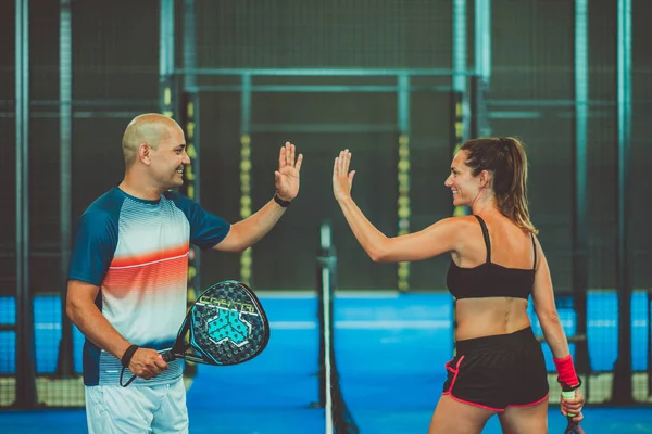 İki padel tenisçinin el sıkışması portresi