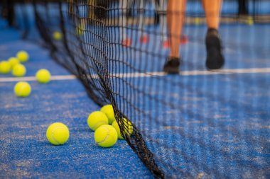 Maçtan sonra sahada tenis topu - Padel topları - Mavi çimenlikteki kortta sarı tenis topları