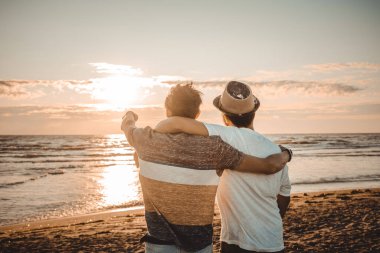 İki arkadaş sahilde gün batımına bakarak birbirlerine sarılırlar. Arkadaşlık ve aşk kavramı