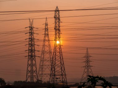 Gün batımında yüksek voltajlı elektrik hatları. Elektrik dağıtım istasyonu