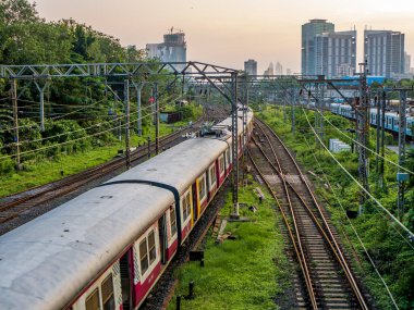 MUMBAI, INDIA - 17 Ekim 2020: Mumbai Suburban Demiryolu, dünyanın en işlek banliyö demiryolu sistemlerinden biri. Günbatımında gökyüzü ile Mumbai Şehri.