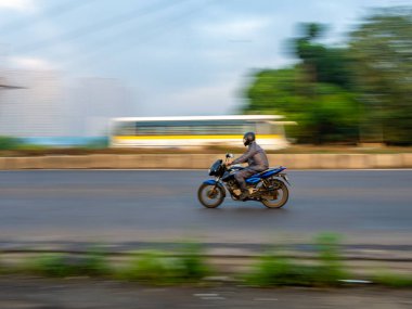 MUMBAI, INDIA - 27 Eylül 2020: KOVID-19 / Coronavirus salgınının karantinası sırasında güneşli bir günde Mumbai sokaklarında motosiklet süren insanlar