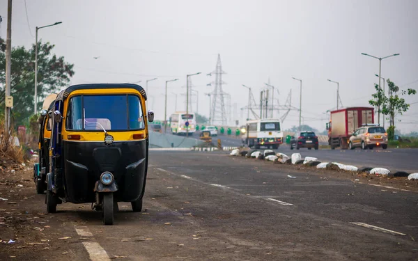 Mumbai caddesinde geleneksel siyah sarı otomobil çekçekçekleri. Mumbai sokaklarında Hint toplu taşımacılığı. Üçlü bisiklet antika motosiklet