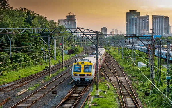 MUMBAI, INDIA - 17 Ekim 2020: Mumbai Suburban Demiryolu, dünyanın en işlek banliyö demiryolu sistemlerinden biri. Günbatımında gökyüzü ile Mumbai Şehri.