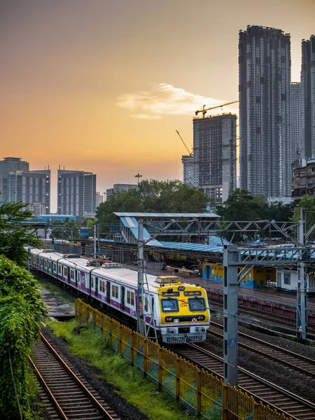 MUMBAI, INDIA - 17 Ekim 2020: Mumbai Banliyö Demiryolu, dünyanın en işlek banliyö demiryolu sistemlerinden biri. Günbatımında gökyüzü ile Mumbai Şehri.