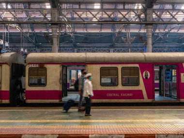 Mumbai, Hindistan - 7 Ocak 2021: Bulanık yüzlü kimliği belirsiz yolcular, Mumbai 'deki işçi sınıfının en yoğun tren istasyonlarından biri olan CST istasyonunda yürüyor.