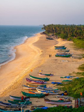 Udupi, INDIA - 26 Aralık 2024: Arap Denizi sahilinde kum ve mavi suyla geleneksel balıkçı teknesinin havadan görünüşü. Karnataka 'daki Kapu plajı..
