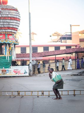 Udupi, INDIA - 27 Aralık 2024: Etnik kıyafetler giyen Hintli adam tapınağın dışında ibadet ediyor
