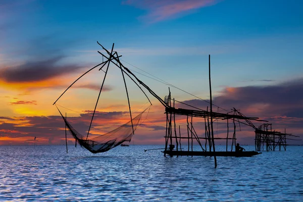 Silueta pescador en barco en el lago con acción al pescar, Tailandia — Foto de Stock